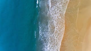Waves on a sandy beach seen from above