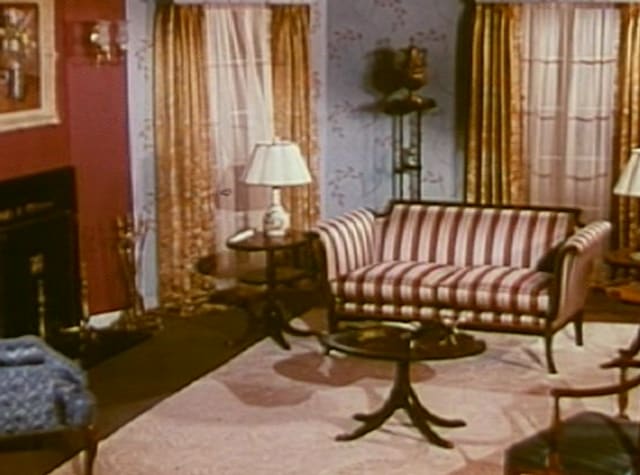 A 1940s living room with a striped sofa and lamps