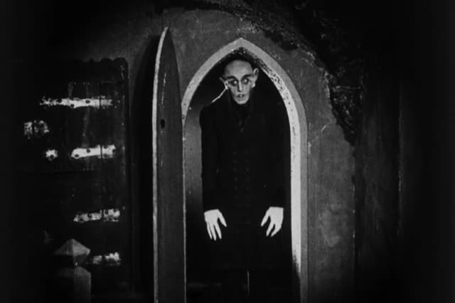 Count Orlok standing in an arched doorway, from Nosferatu