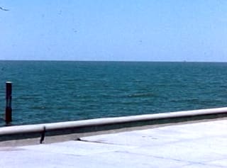 Blue sea meeting the sky beyond a sea wall