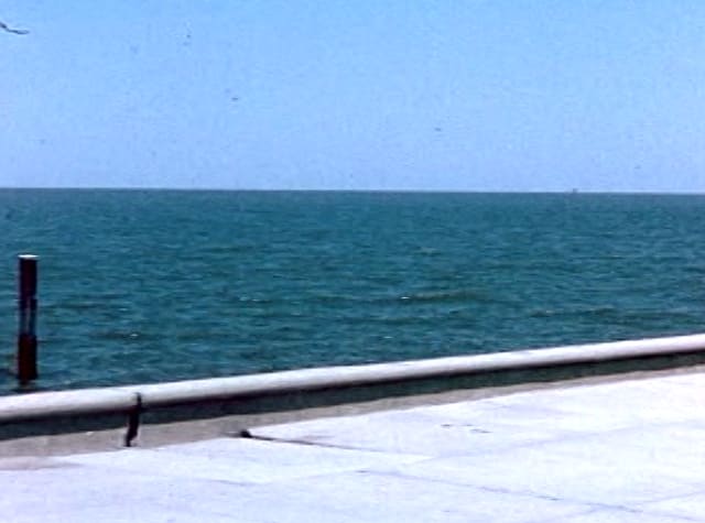 Blue sea meeting the sky beyond a sea wall