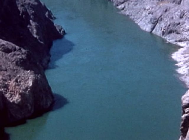 A teal river between rocky canyon walls