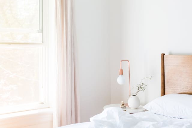 A white bedroom in soft window light